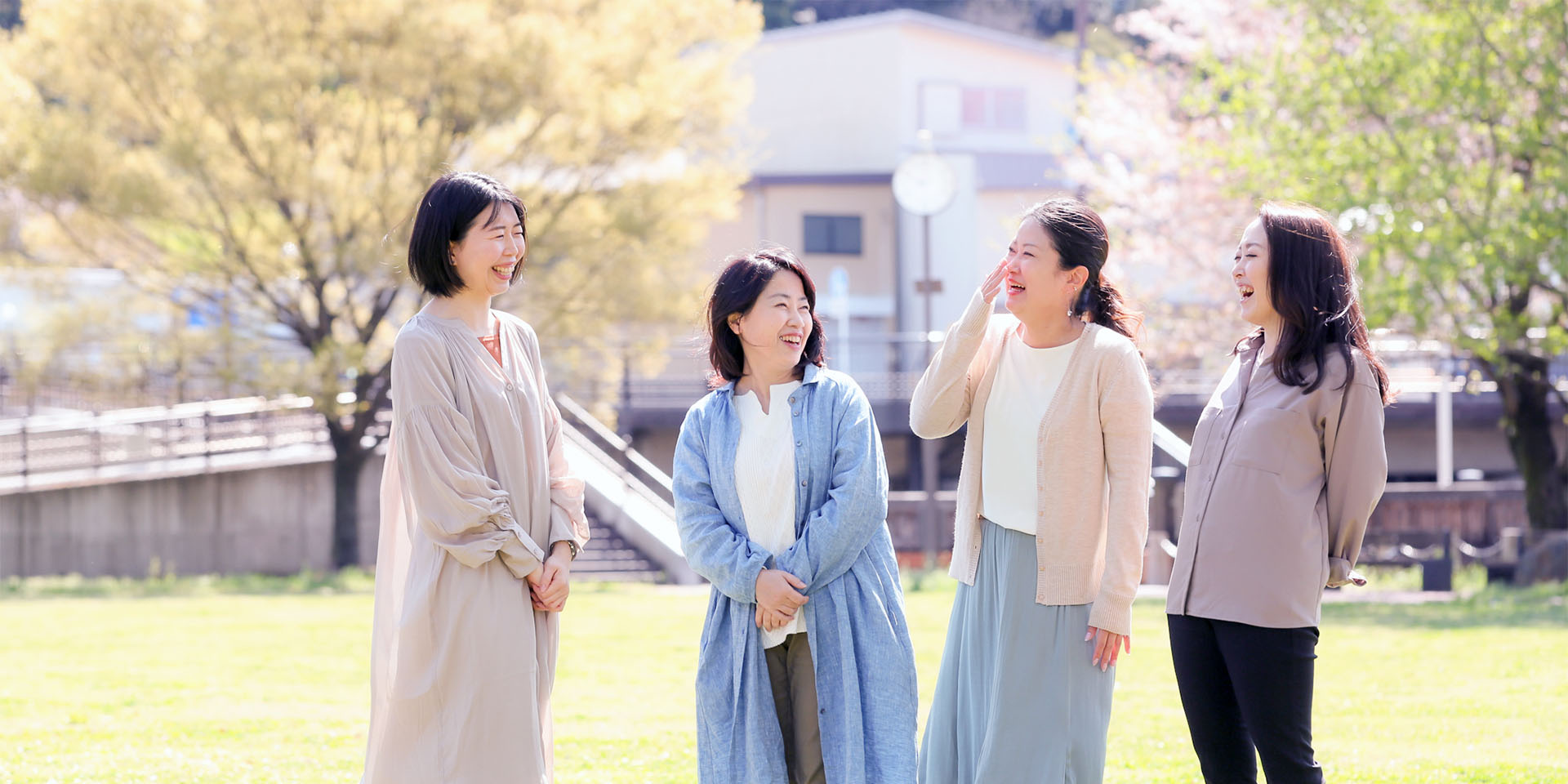 女性複数人が明るい広場で笑っている写真